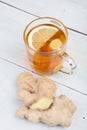 Ginger tea in a glass cup on wooden background