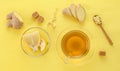 Ginger tea with lemon and spices in glass Cup with spoon and sugar on yellow paper background, top view Royalty Free Stock Photo