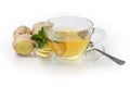 Ginger tea with mint in glass cup, fresh ginger root