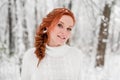 Ginger tender girl in white sweater in winter forest. Snow december in park. Christmas time. Royalty Free Stock Photo