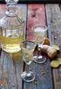 Ginger tincture or ale on wooden background. Spice yellow liqueur in a glass. Homemade Alcohol drink. Rustic style Royalty Free Stock Photo