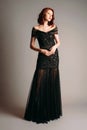 Ginger woman in maxi black gown. Candid portrait. Transparent slim shiny dress with v neckline. Stunning look for an event, female