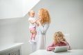 Ginger woman talking on the smartphone and holding a baby Royalty Free Stock Photo