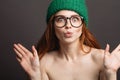 Ginger woman wearing glasses and green hat pouting her lips ready for kiss Royalty Free Stock Photo