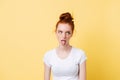 Ginger woman in white t-shirt showing grimace