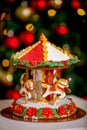 Gingerbread carousel in front of defocused lights of Chrismtas decorated fir tree. Holiday sweets. New Year and Christmas theme. F