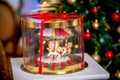 Gingerbread carousel in a gift box in front of defocused lights of Chrismtas decorated fir tree. Holiday sweets. New Year and Chri