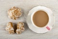 Gingerbread, coffee with milk in cup on saucer on table. Top view