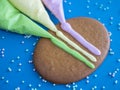 Gingerbread and colored icing for cookie decorating on blue background with sprinkles Royalty Free Stock Photo