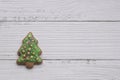 Gingerbread cookie of green Christmas tree on white wood background Royalty Free Stock Photo