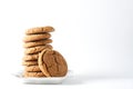 A gingerbread cookie leans on a stack on cookies on a white plate isolated on a white background; copy space Royalty Free Stock Photo