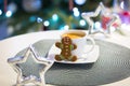Gingerbread cookie man at the cup of hot coffee and christmas tree lights in background Royalty Free Stock Photo