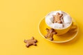 Gingerbread cookie-men in yellow mug of hot coffee with marshmallow
