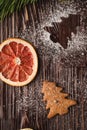 Gingerbread cookies in Christmas fir-tree, powdered sugar on wooden background, citrus dried grapefruit