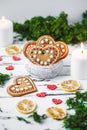 Gingerbread Cookies hearts in a cup, two candles on a white wooden background Valentines day concept Royalty Free Stock Photo