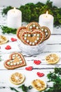 Gingerbread Cookies hearts in a cup, two candles on a white wooden background Valentines day concept Royalty Free Stock Photo