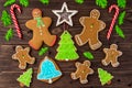 Gingerbread cookies, snowflakes, Christmas tree, bell, man, hanging with ribbon over a dark brown wood background. Free Royalty Free Stock Photo