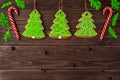 Gingerbread cookies, snowflakes, Christmas tree, bell, man, hanging with ribbon over a dark brown wood background. Free Royalty Free Stock Photo