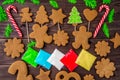 Gingerbread cookies, snowflakes, Christmas tree, bell, man, hanging with ribbon over a dark brown wood background. Free Royalty Free Stock Photo