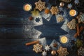 Gingerbread cookies, spices and burning candles on a star from icing sugar on a dark blue wooden background as a Christmas flat Royalty Free Stock Photo