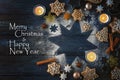 Gingerbread cookies, spices and burning candles on a star from icing sugar on a dark blue wooden background, text Merry Christmas Royalty Free Stock Photo