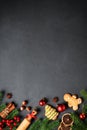 Gingerbread cookies, spices and Christmas decorations at black. Royalty Free Stock Photo