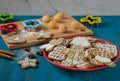 Gingerbread cookies of various shapes lie on a red dish, which stands on a blue wooden table Royalty Free Stock Photo