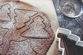 Gingerbread dough, rolled out with different Christmas shapes cut into it and sprinkled with powdered sugar on a table Royalty Free Stock Photo