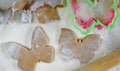 Gingerbread dough is rolled on the table. Figures are cut out of it with moulds. The table is suppaned with flour