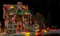 Gingerbread family near snow-covered homemade gingerbread house