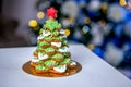 Gingerbread fir tree in front of defocused lights of Chrismtas decorated living room. Holiday sweets. New Year and Christmas theme