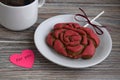 Gingerbread in the form of a flower of a red rose , paper in the form of heart with an inscription and a cup with coffee Royalty Free Stock Photo