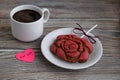 Gingerbread in the form of a flower of a red rose, paper in the form of pink heart and a cup with coffee Royalty Free Stock Photo