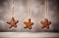 Gingerbread gingerbread hanging from a string as Christmas decorations on a concrete wooden background. AI-Generated