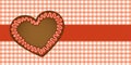 Gingerbread heart on red checkered tablecloth