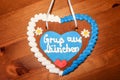 Gingerbread heart with written slogan: Greetings from Munich, Bavarian symbol and Munich landmark, Gingerbread candy on wooden