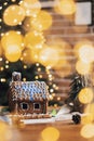 Gingerbread house on Christmas table with decorations, candles in living room Royalty Free Stock Photo