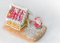 Gingerbread house decorated with candies Santa Claus on white background. Christmas Treat Royalty Free Stock Photo