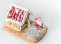 Gingerbread house decorated with colorful candies and Santa Claus on white background. Christmas Treat Royalty Free Stock Photo