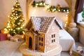 Gingerbread house over defocused lights of Chrismtas decorated fir tree Royalty Free Stock Photo