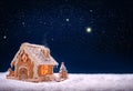Gingerbread house on the white snow isolated on night sky