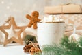 Gingerbread man cookie in cup of hot cocoa or coffee with marshmallow, fir tree, gifts and warm cozy sweater. Christmas Royalty Free Stock Photo