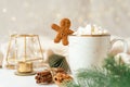 Gingerbread man cookie in cup of hot cocoa or coffee with marshmallow, fir tree and warm cozy sweater. Christmas Royalty Free Stock Photo