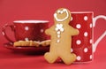 Gingerbread man with red polka dot coffee mug and tea cup Royalty Free Stock Photo