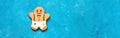 Gingerbread man on turquoise grunge background, banner. Christmas pastries, border. Top view, flat lay, copy space Royalty Free Stock Photo