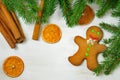 Gingerbread mans and Christmas tree branches on wooden backgroun