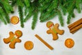 Gingerbread mans and Christmas tree branches on wooden background