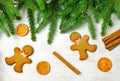 Gingerbread mans and Christmas tree branches on wooden background