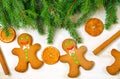 Gingerbread mans and Christmas tree branches on wooden background