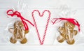Gingerbread men and heart made of lollipops on a white wooden background. Delicious gifts for Valentine`s Day. Flatlay compositio